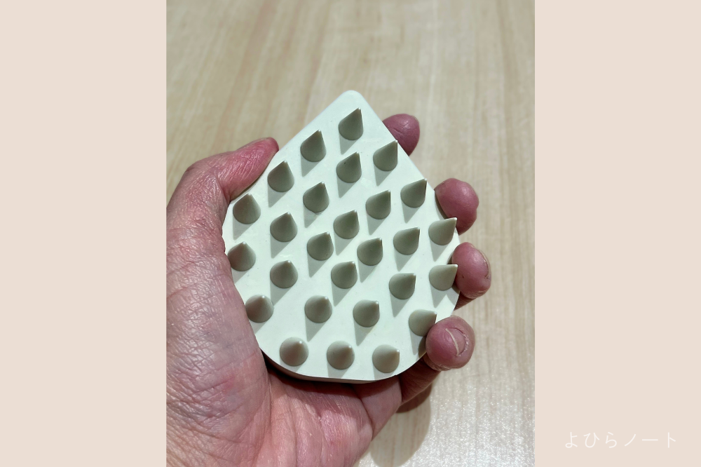 エトヴォス リラクシングマッサージブラシを手に持つ写真。